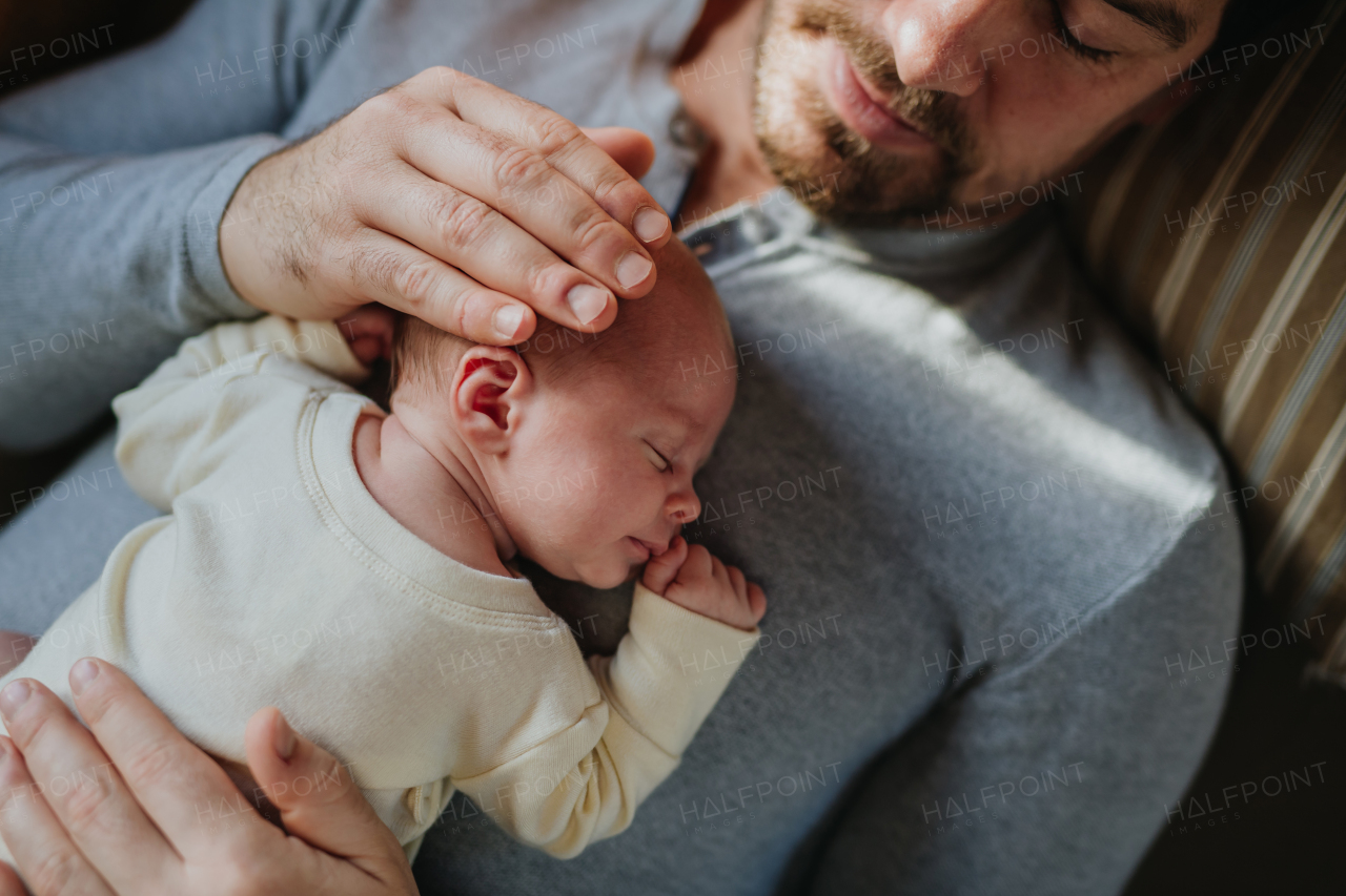 Close-up of father cuddling his little new born baby.