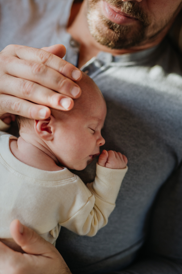 Close-up of father cuddling his little new born baby.