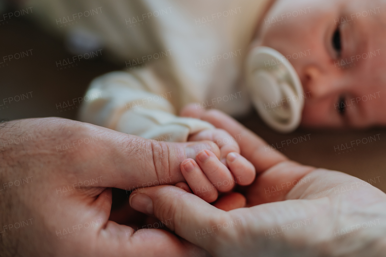 Close-up of parents cuddling their newborn son.