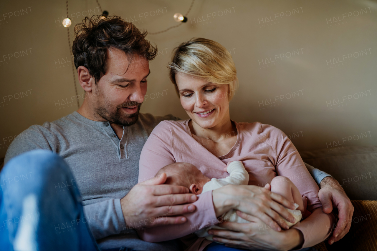 Close-up of parents cuddling their newborn son.