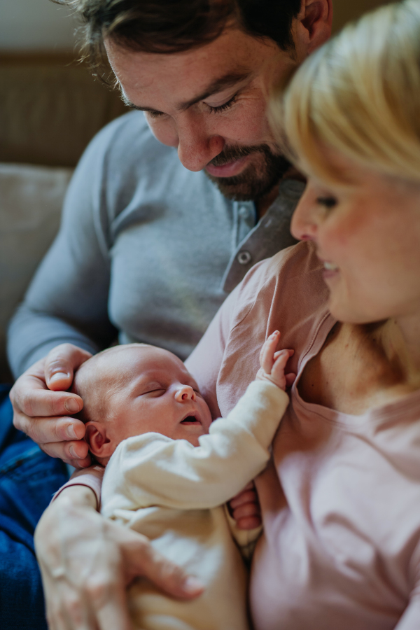 Close-up of parents cuddling their newborn son.