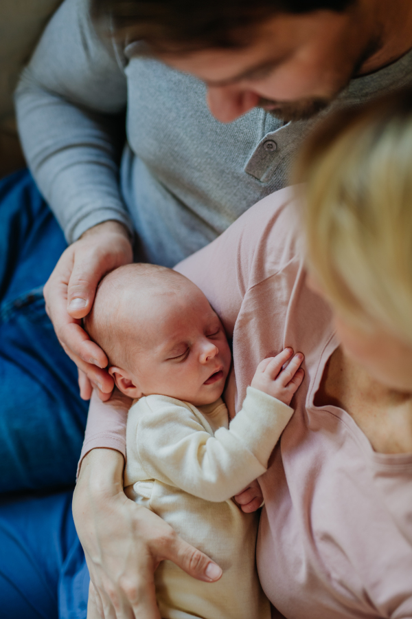 Close-up of parents cuddling their newborn son.