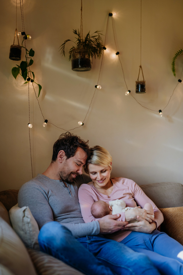 Close-up of parents cuddling their newborn son.