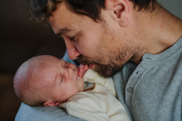 Close-up of father cuddling his little new born baby.