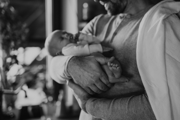 Close-up of father holding his little new born baby, black and white image.