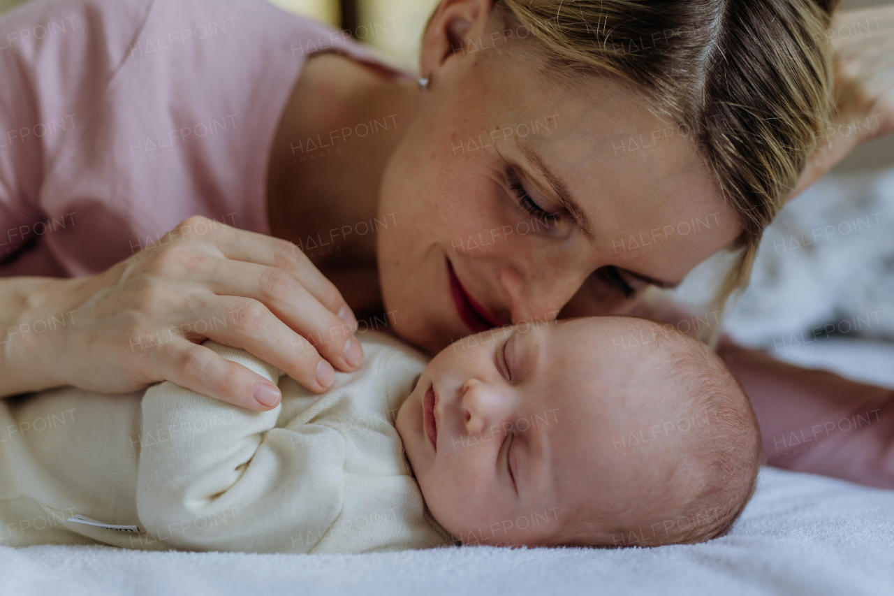 Mother cuddling with her newborn baby in the bad.