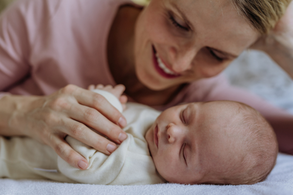 Mother cuddling with her newborn baby in the bad.