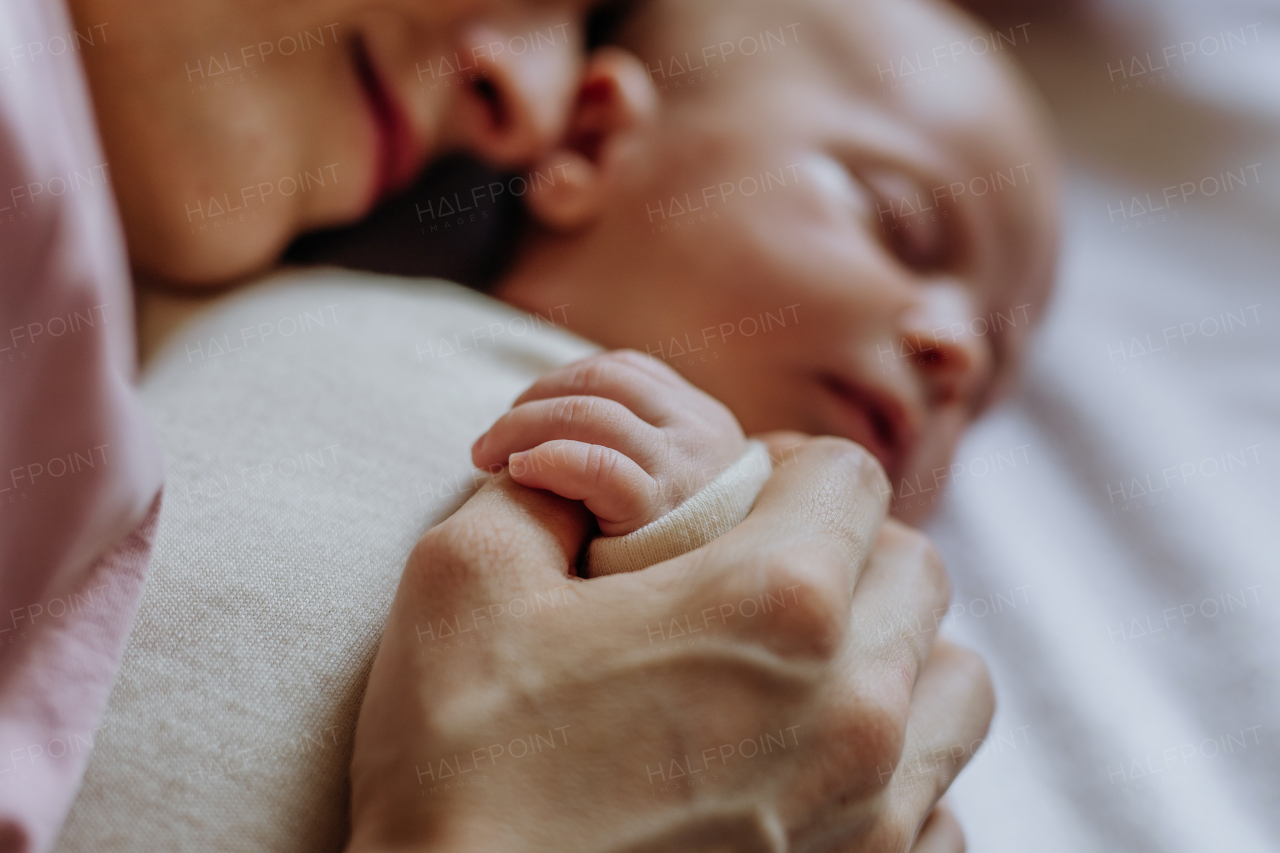 Mother cuddling with her newborn baby in the bad.