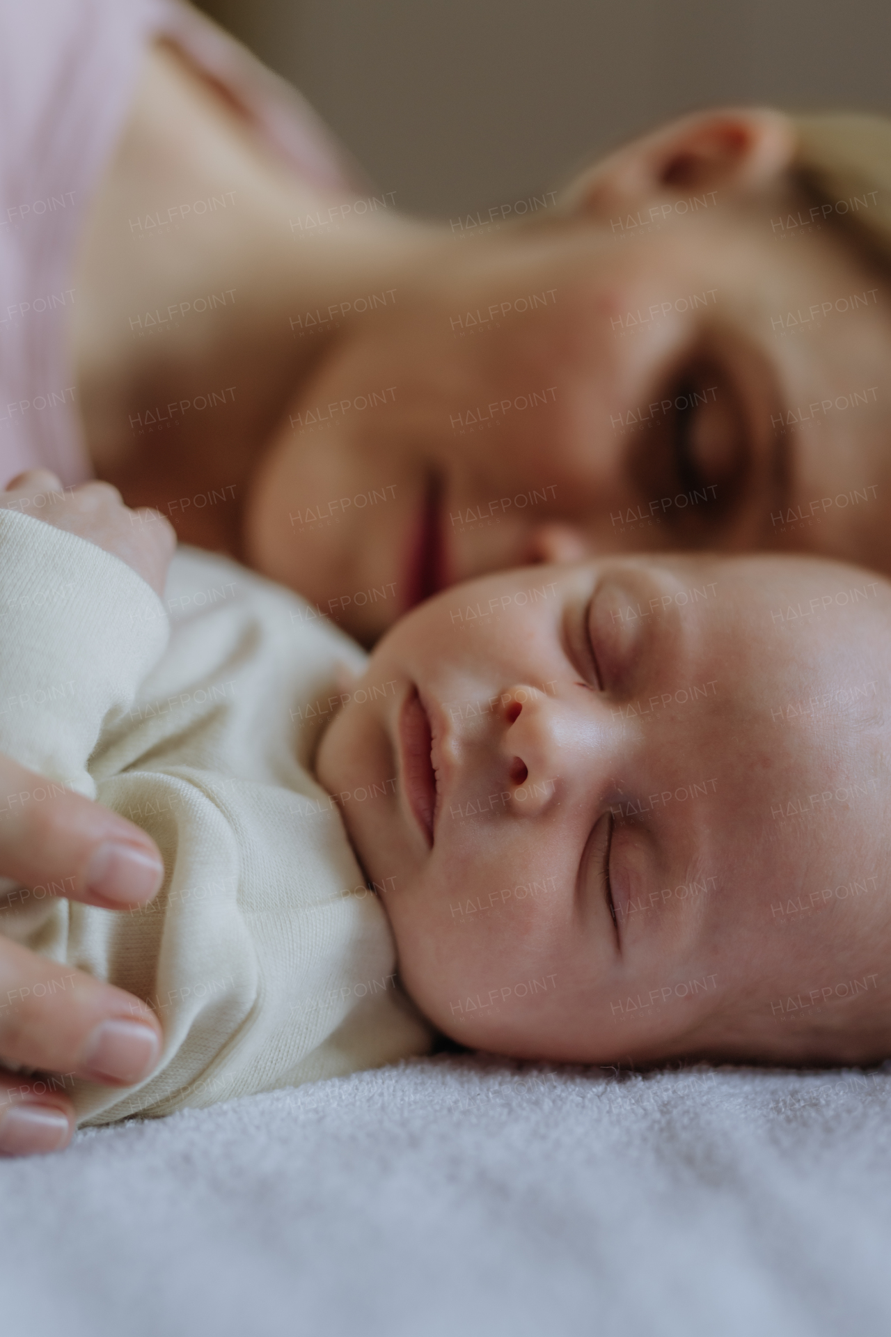 Mother cuddling with her newborn baby in the bad.