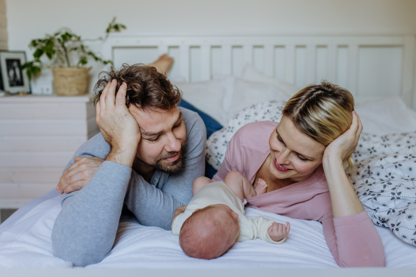 Close-up of parents cuddling their newborn son.