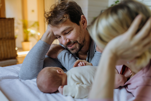 Close-up of parents cuddling their newborn son.