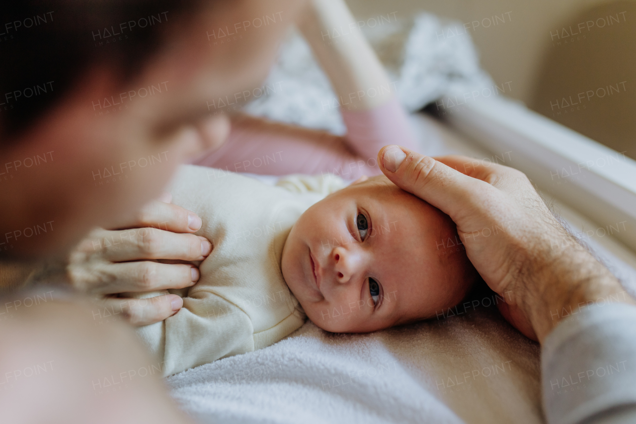 Close-up of parents cuddling their newborn son.