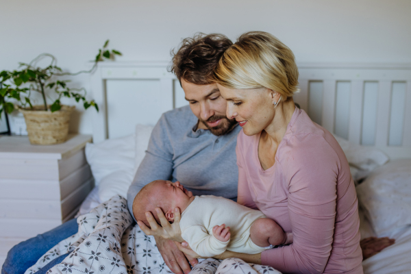 Close-up of parents cuddling their newborn son.