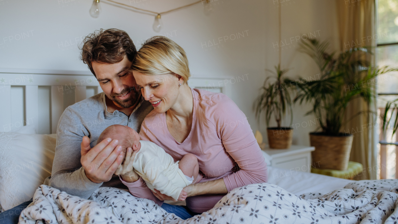 Close-up of parents cuddling their newborn son.