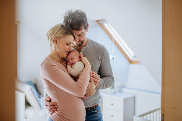 Parents holding their newborn son in their home.