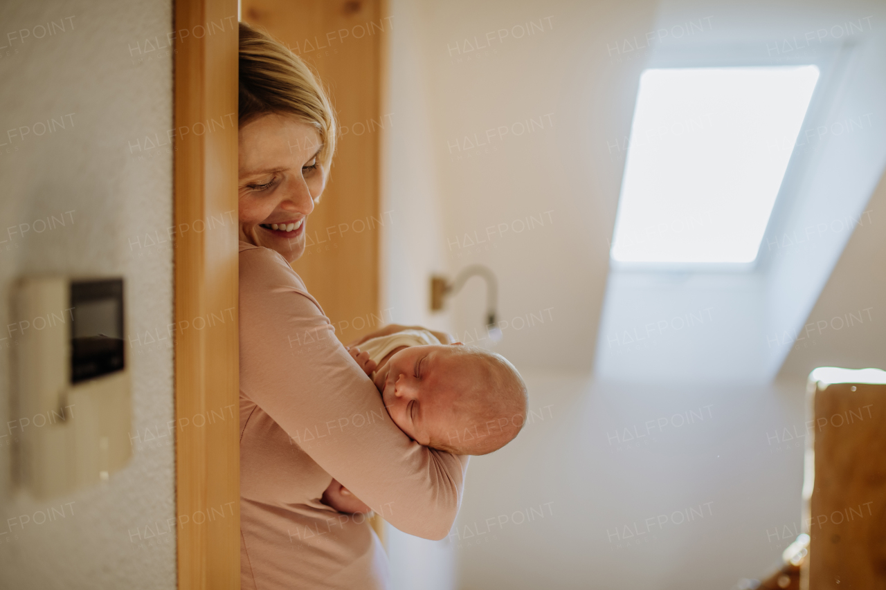 Mother cuddling her little newborn baby in their home.