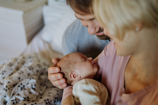 Close-up of parents cuddling their newborn son.