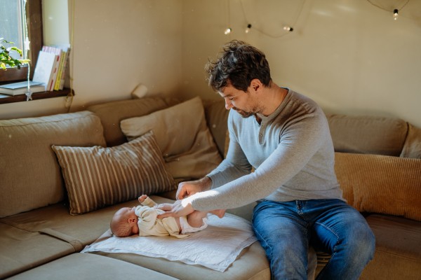 Mature father changing diaper his newborn baby.