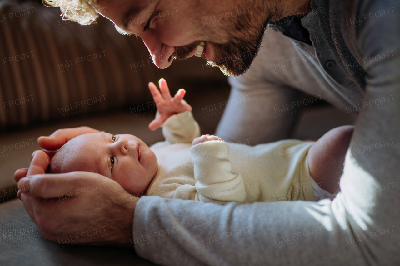 Close-up of father cuddling his little new born baby.