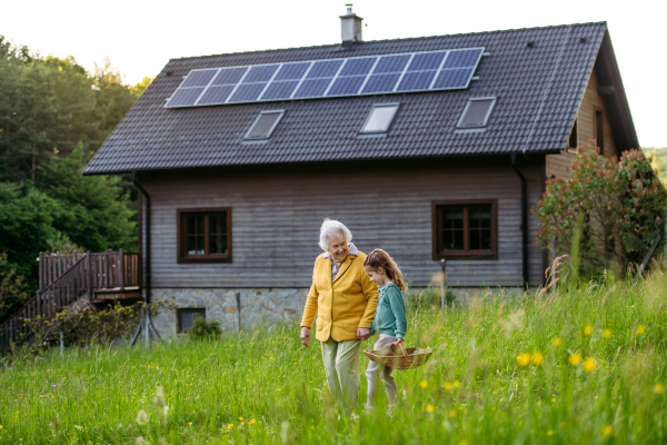 Granddaughter spending time with elderly grandma, companionship. Senior lady on walk in nature. Weekend in cottage.