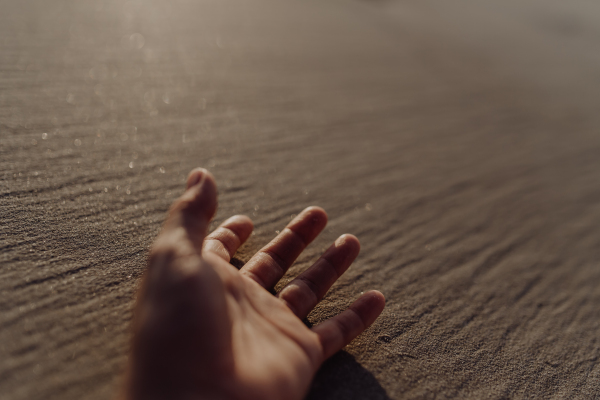 Close-up of a hand on a beach.