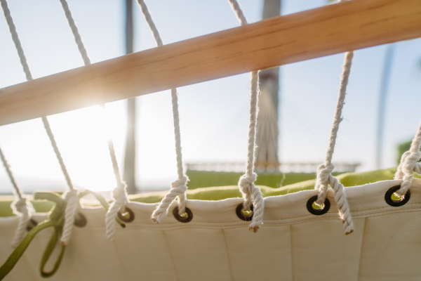 Close up of hammock hanging on palms, concept of summer exotic holiday.