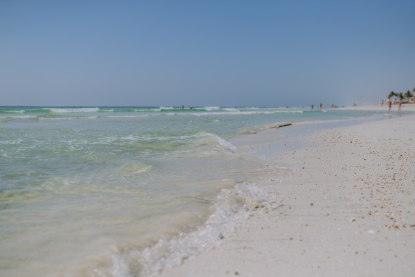 View of ocean and beach during hot sunny day.