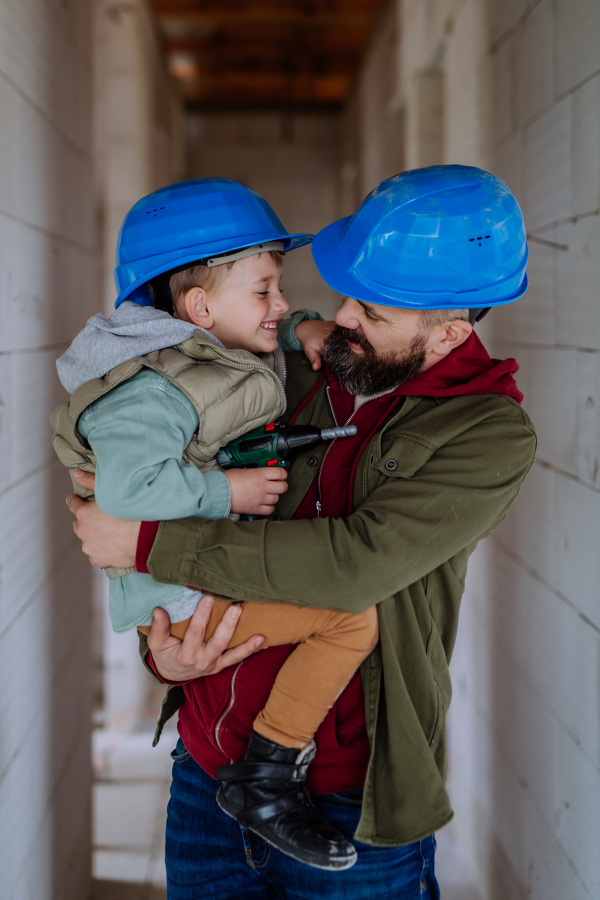 Father and his little son cuddling in their unfinished home.