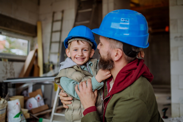 Father and his little son cuddling in their unfinished home.