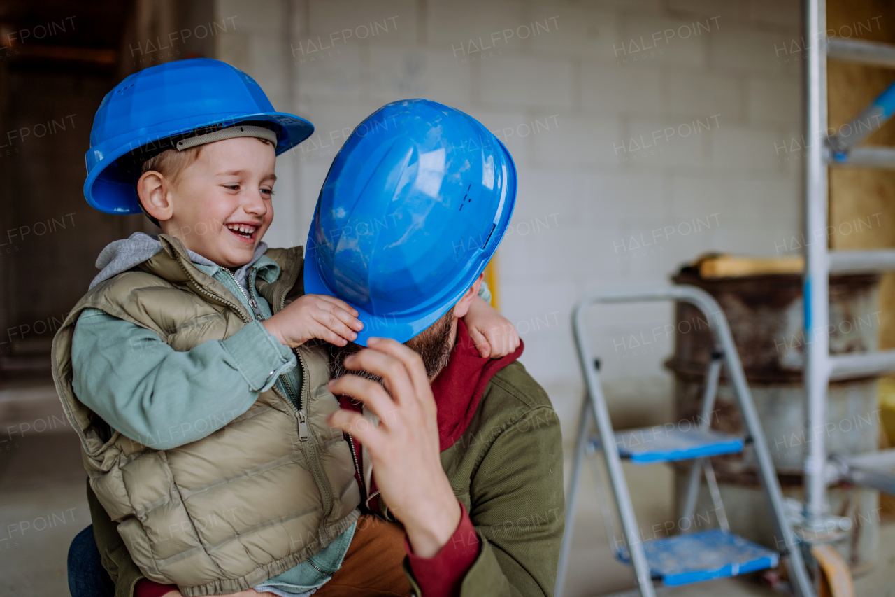 Father and his little son having fun in their unfinished home.