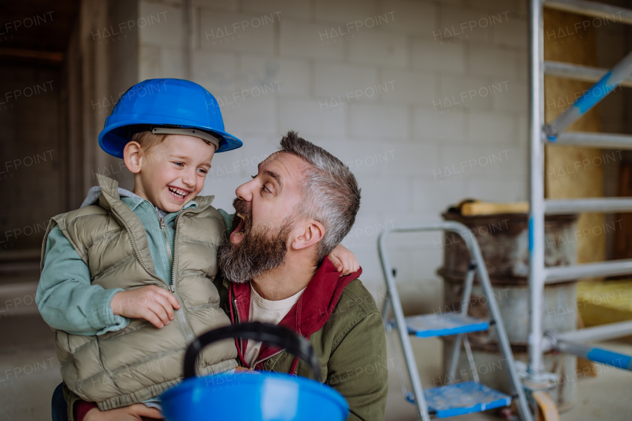 Father and his little son having fun in their unfinished home.