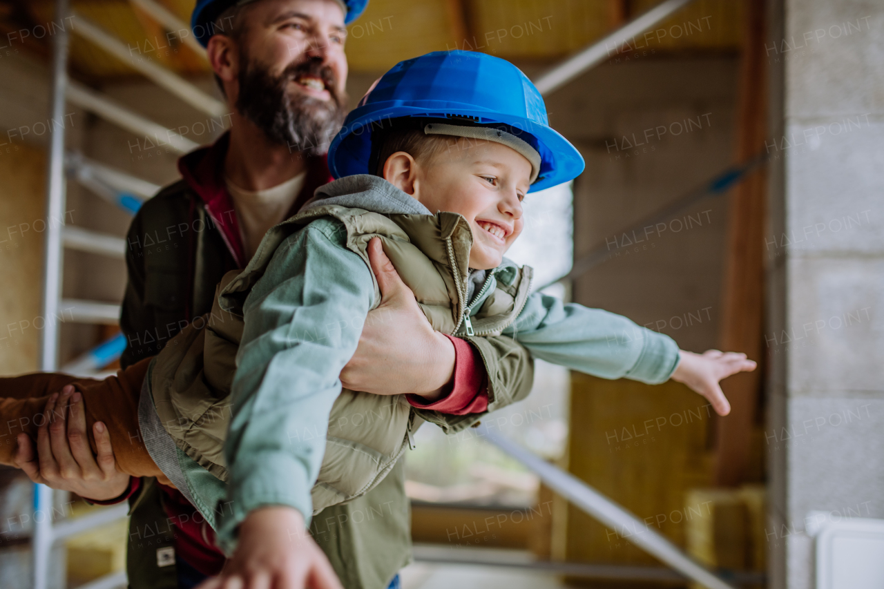 Father and his little son having fun in their unfinished home.