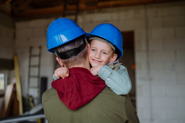 Father and his little son cuddling in their unfinished home.