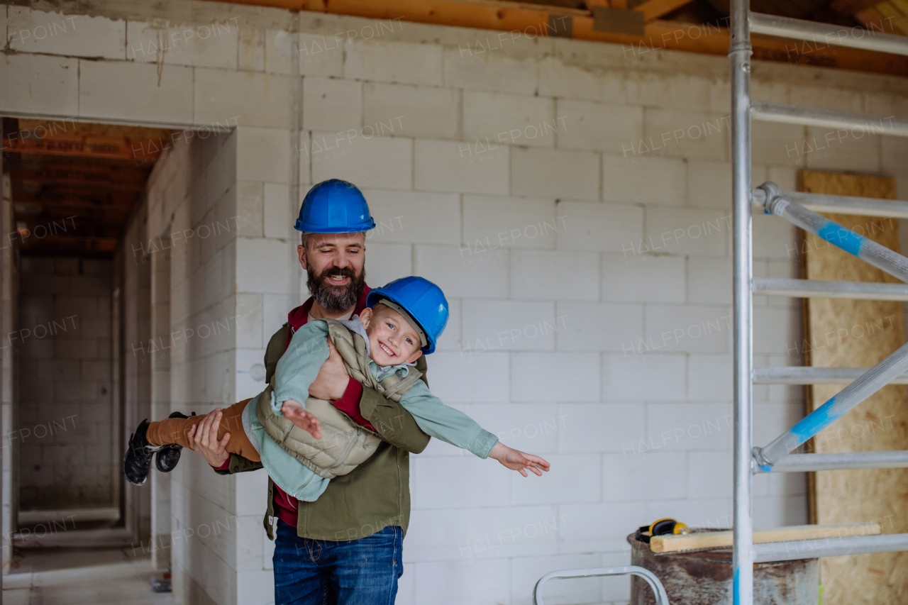 Father and his little son having fun in their unfinished home.