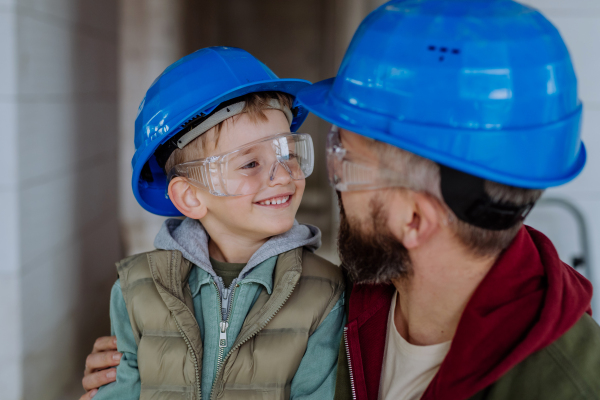 Father and his little son having fun in their unfinished home.