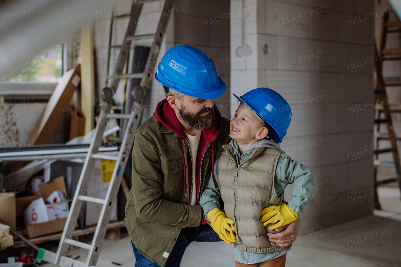 Father and his little son having fun in their unfinished home.