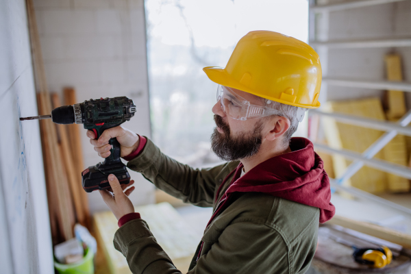 Mature man working in his unfinished house.