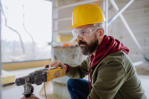 Portrait of mature man working in his new unfinished house.