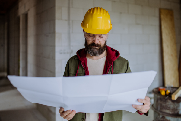 Portrait of mature man working in his new unfinished house.