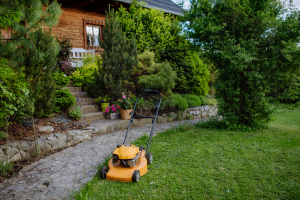 A lawn mower in the garden, garden work concept.