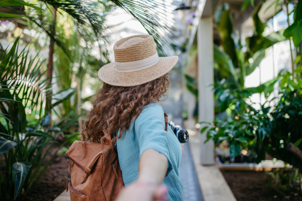 Rear view of young beautiful woman in botanical garden.