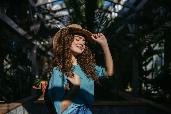 Portrait of young beautiful woman in botanical garden.