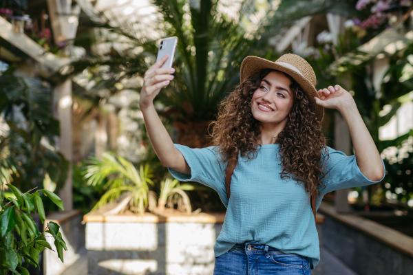 Young woman in a botanical garden taking selfie, concept of tourist and holiay.