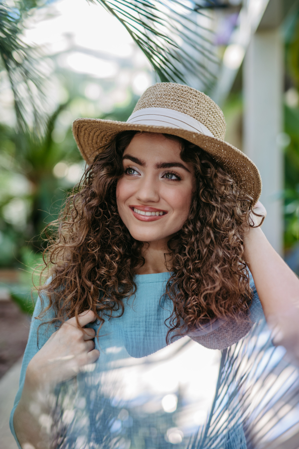 Portrait of young beautiful woman in botanical garden.