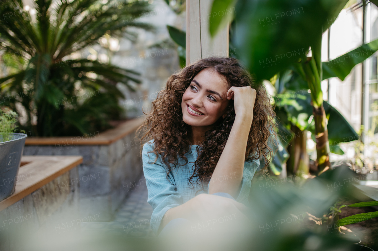 Portrait of young beautiful woman in botanical garden.