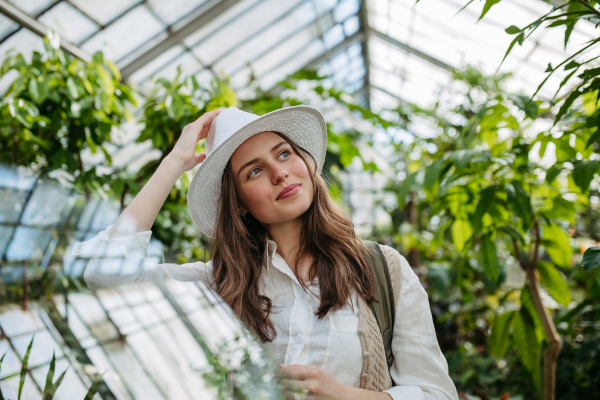 Portrait of young happy woman in a greenhouse.