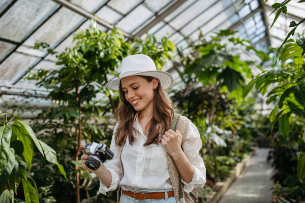 Portrait of a young woman with camera in jungle.