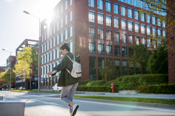 Rear view of young happy woman in a city.