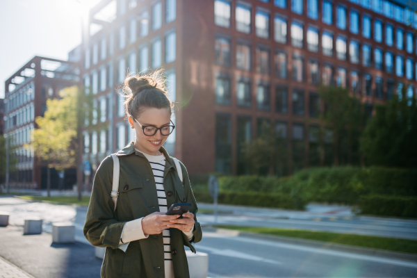 Portrait of a young woman walking in a city.