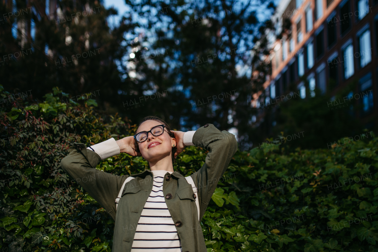 Portrait of young woman enjoying nature in a city park.